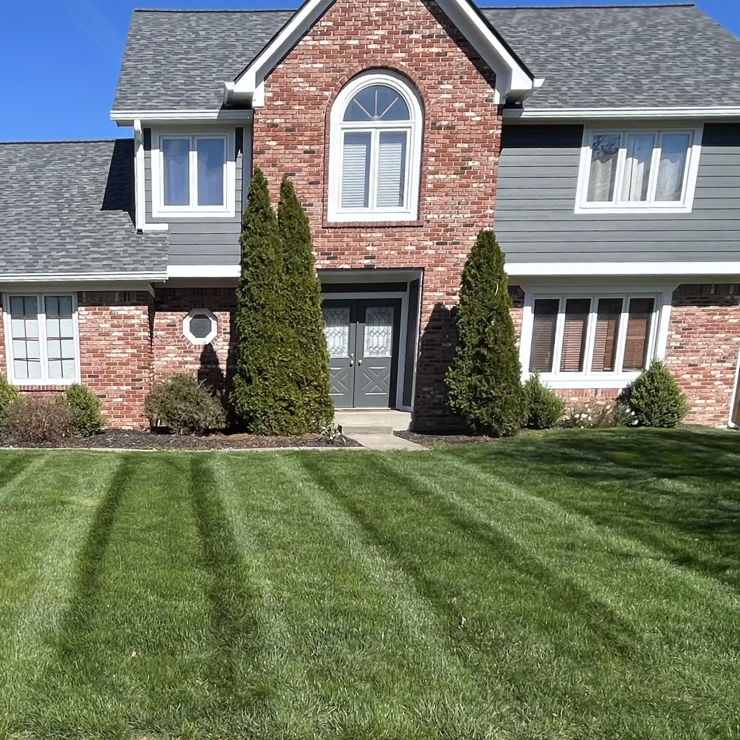 A two-story suburban home with a recently mown lawn